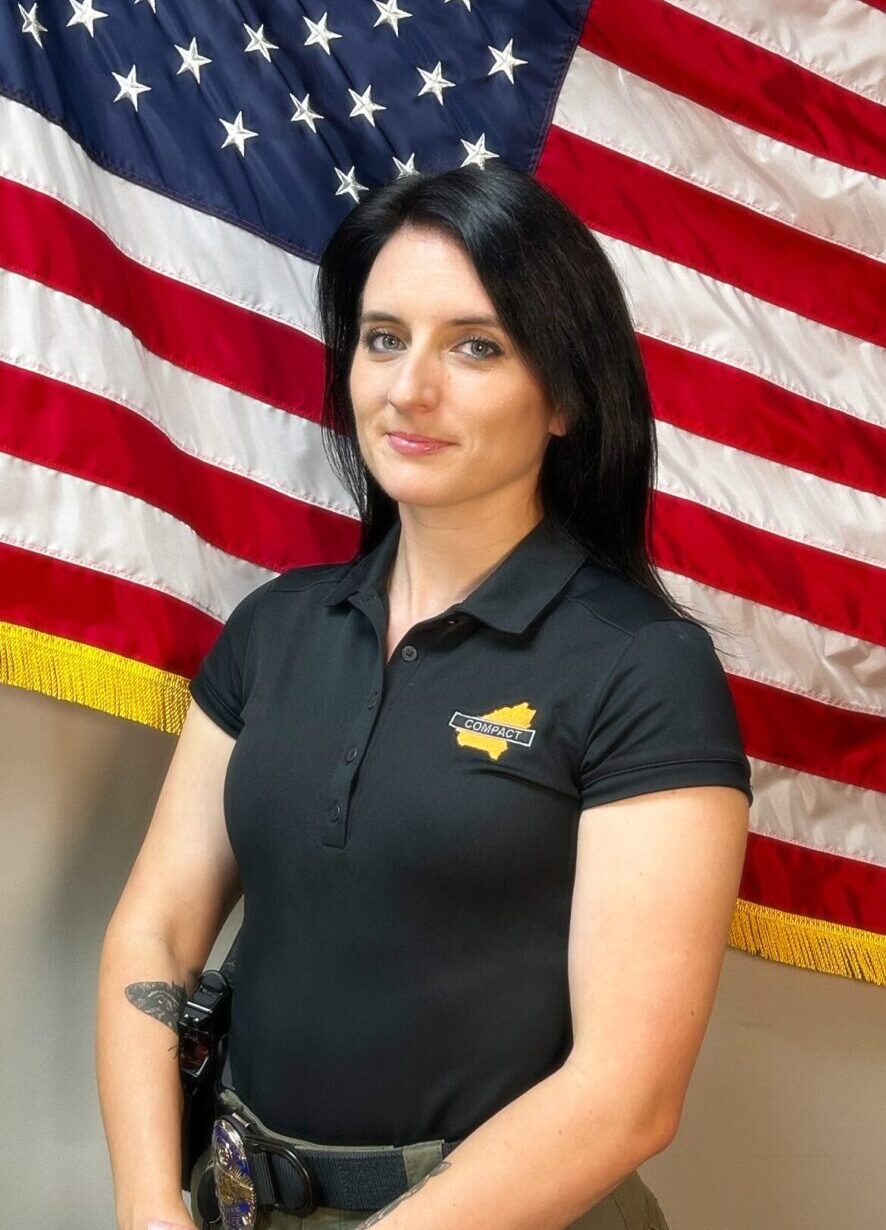 Detective Callie Flores standing in front of an American flag.